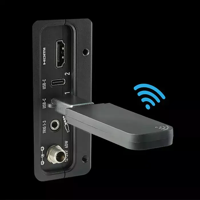 A wireless receiver is plugged into a television.