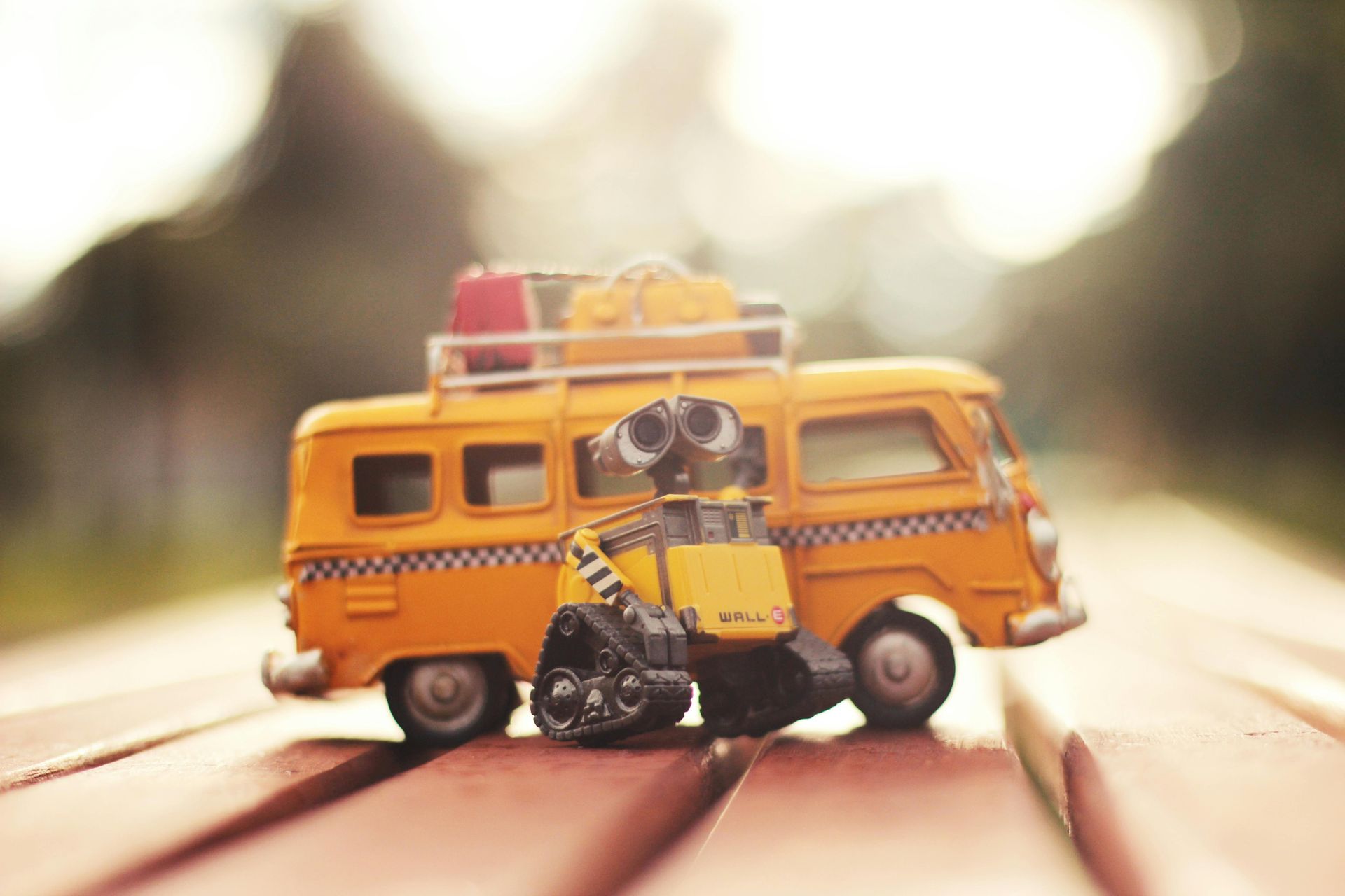 Wall e is sitting on the back of a toy van.