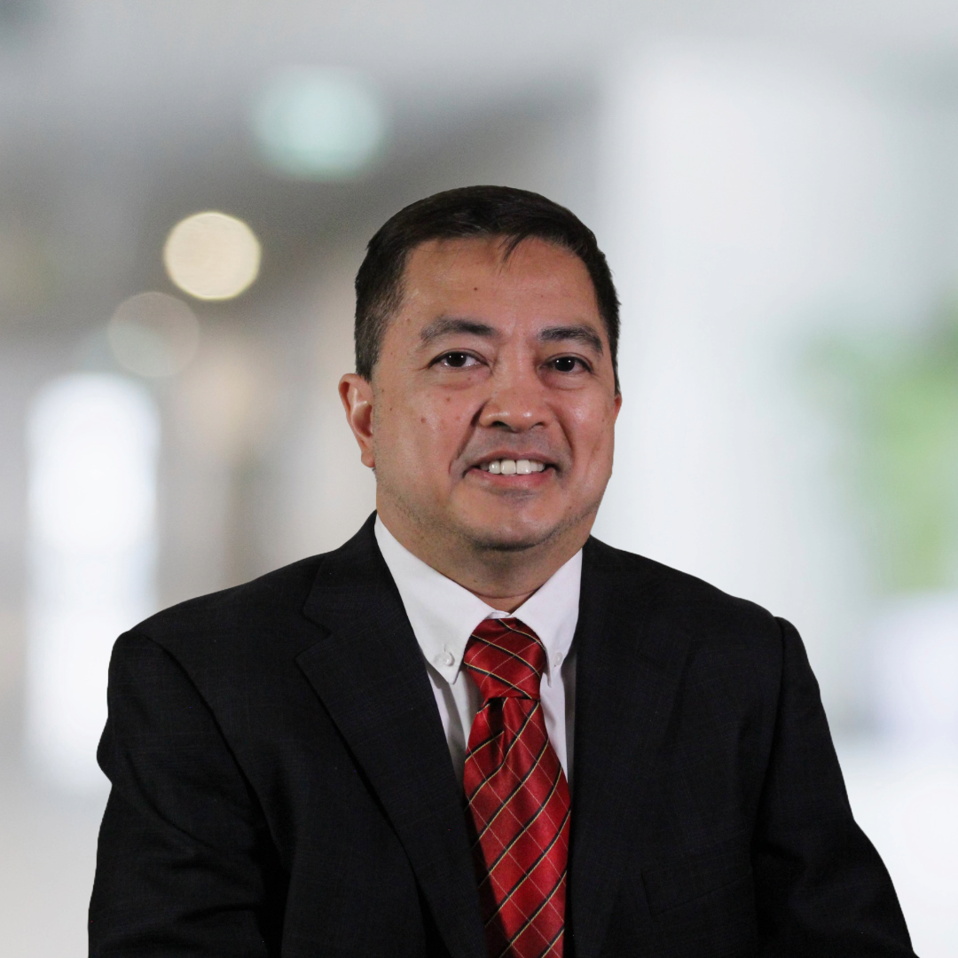 A man in a suit and tie is smiling for the camera