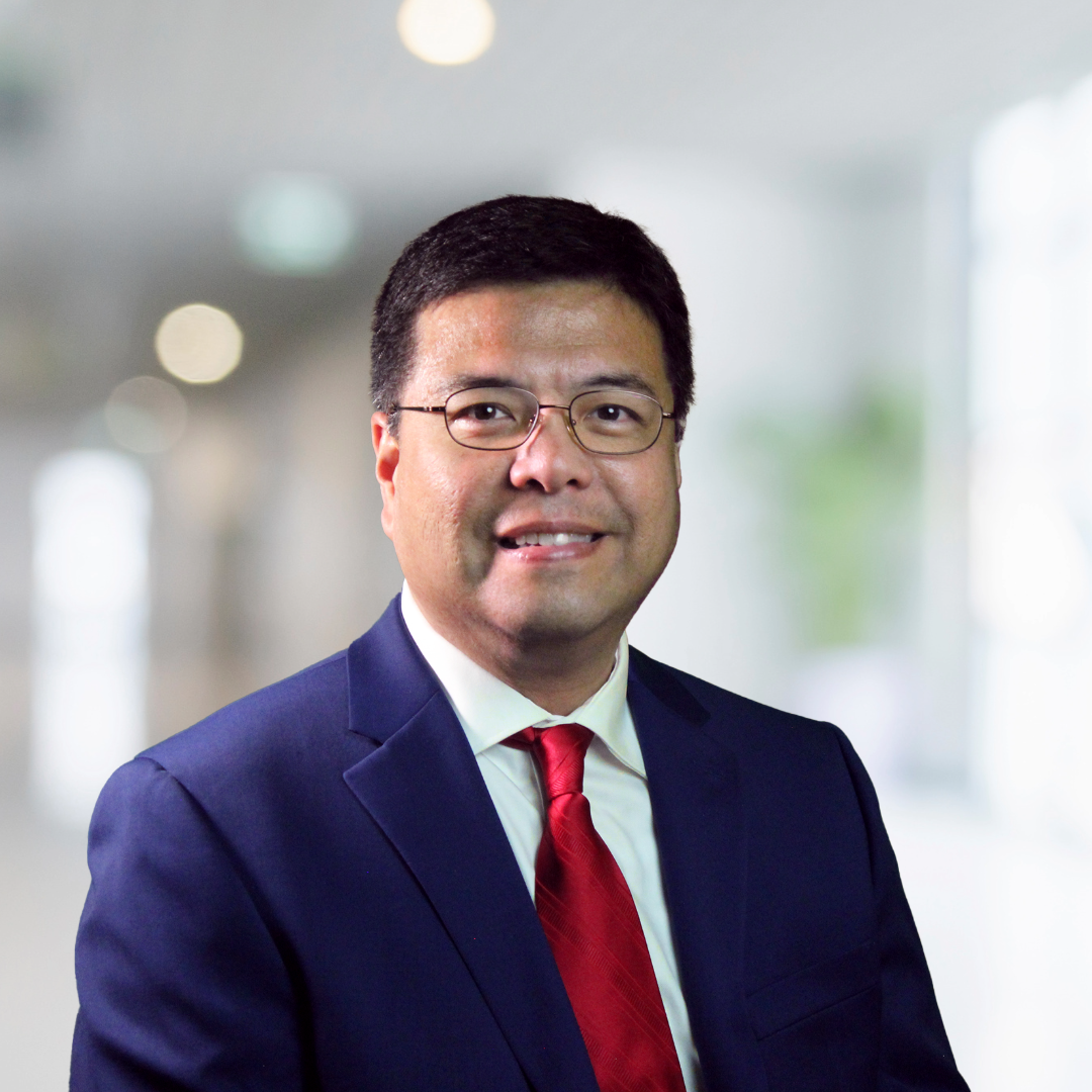A man in a suit and tie is smiling for the camera