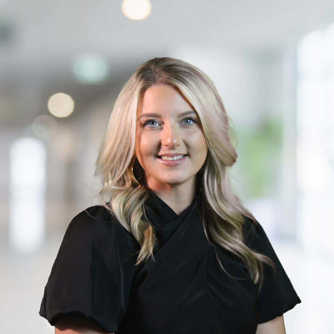 The woman is wearing a black shirt and smiling for the camera.