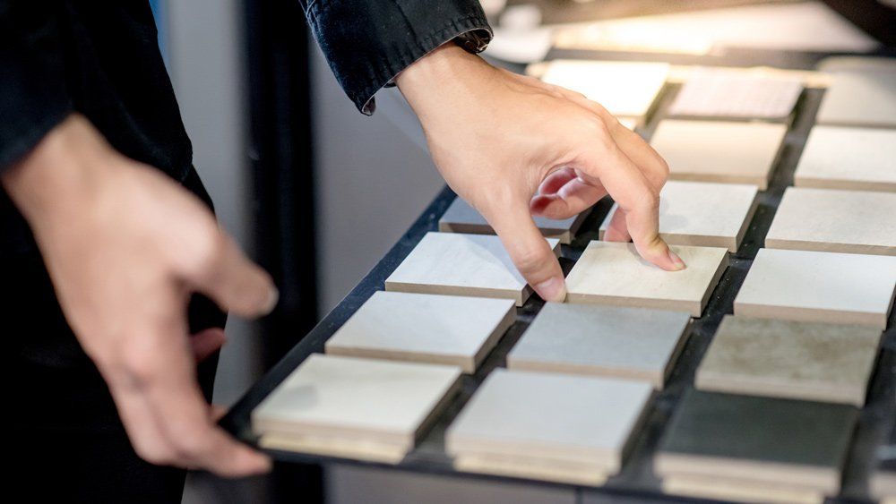 Choosing Ceramic Sample from Swatch Board — Halifax, NC — Doug’s Tile Company