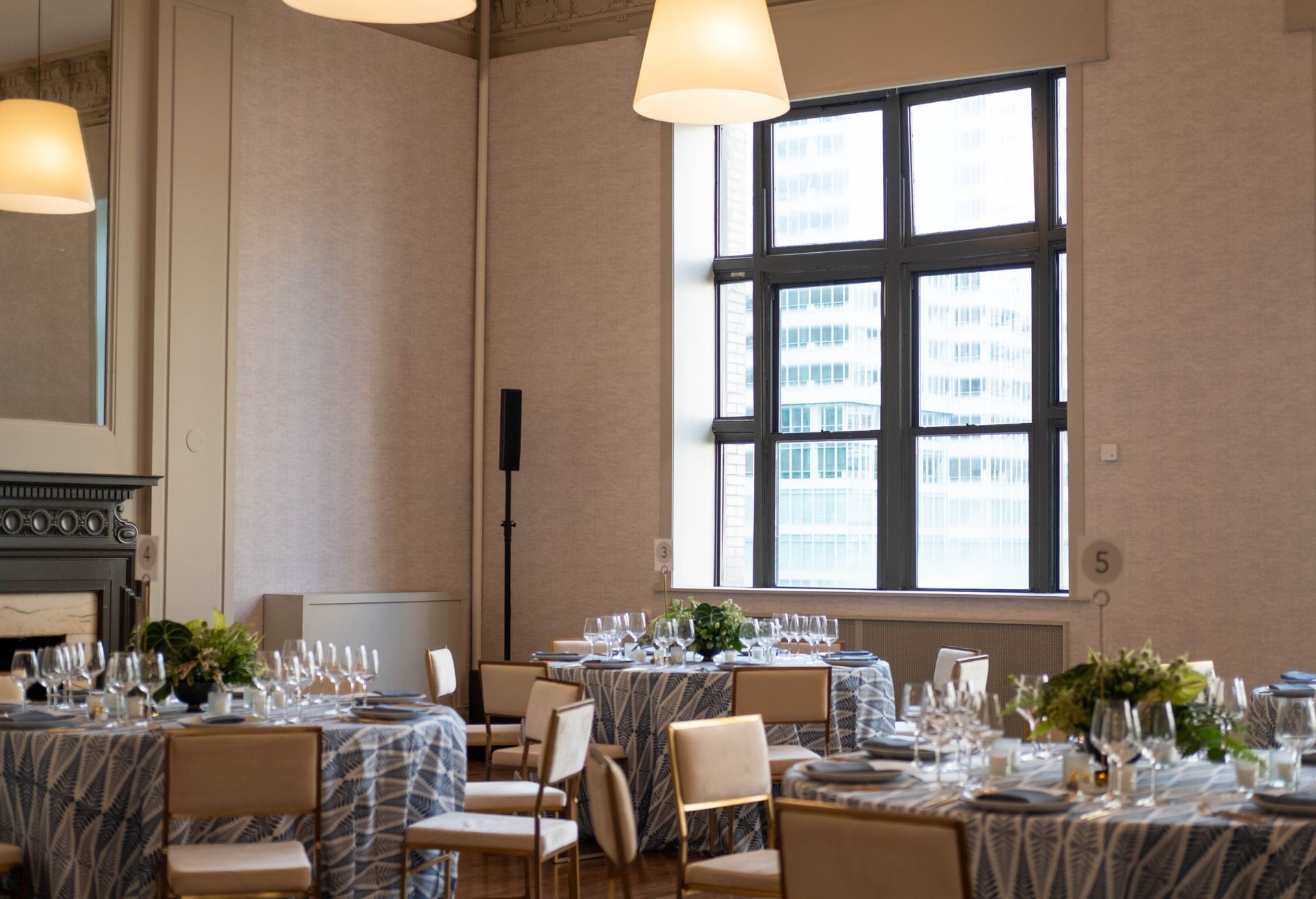 Elegant dining room with round tables, white tablecloths, and large windows