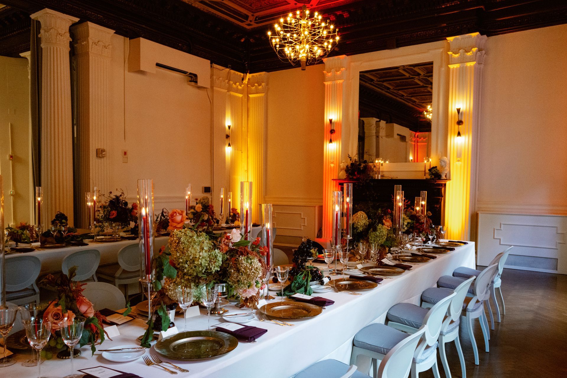 Elegant banquet table set with candles and floral centerpieces in a formal dining room
