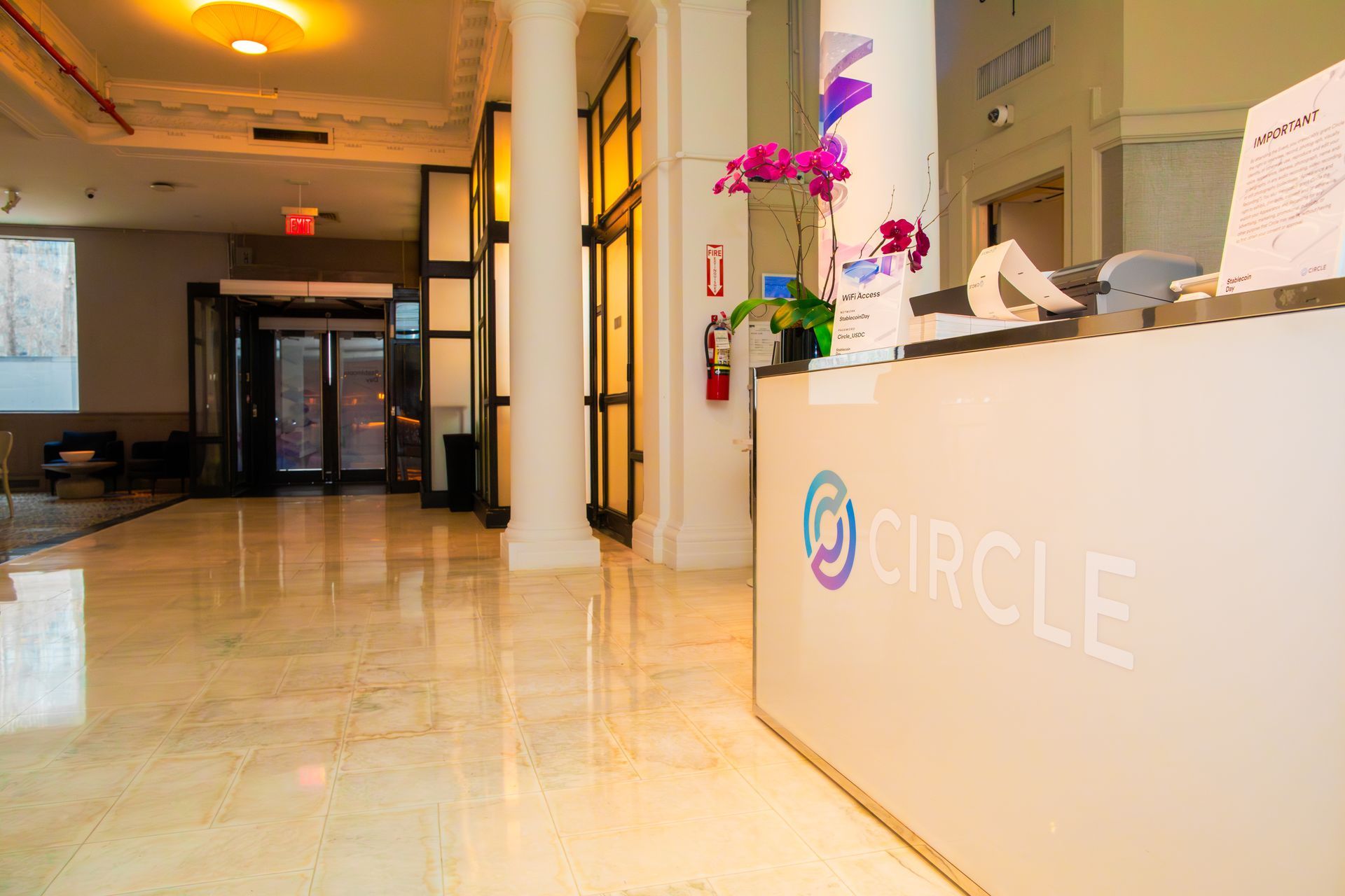 Lobby with a reception desk labeled “CIRCLE,” polished floor, and hallway lighting.