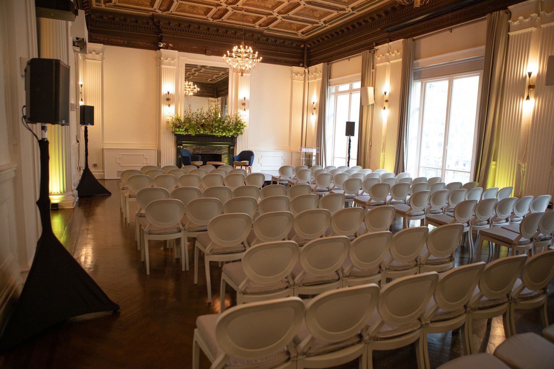 Elegant event hall with rows of white chairs set up for a ceremony or presentation