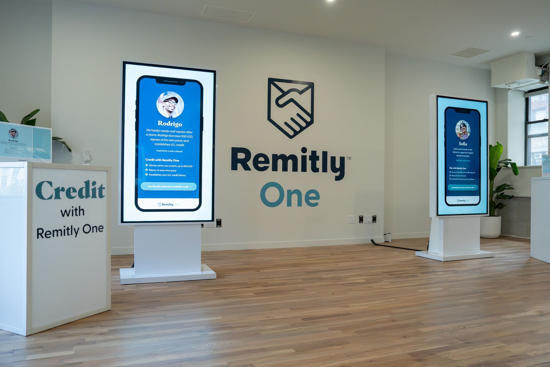 Remitly One office lobby with digital displays, logo wall, and wood flooring