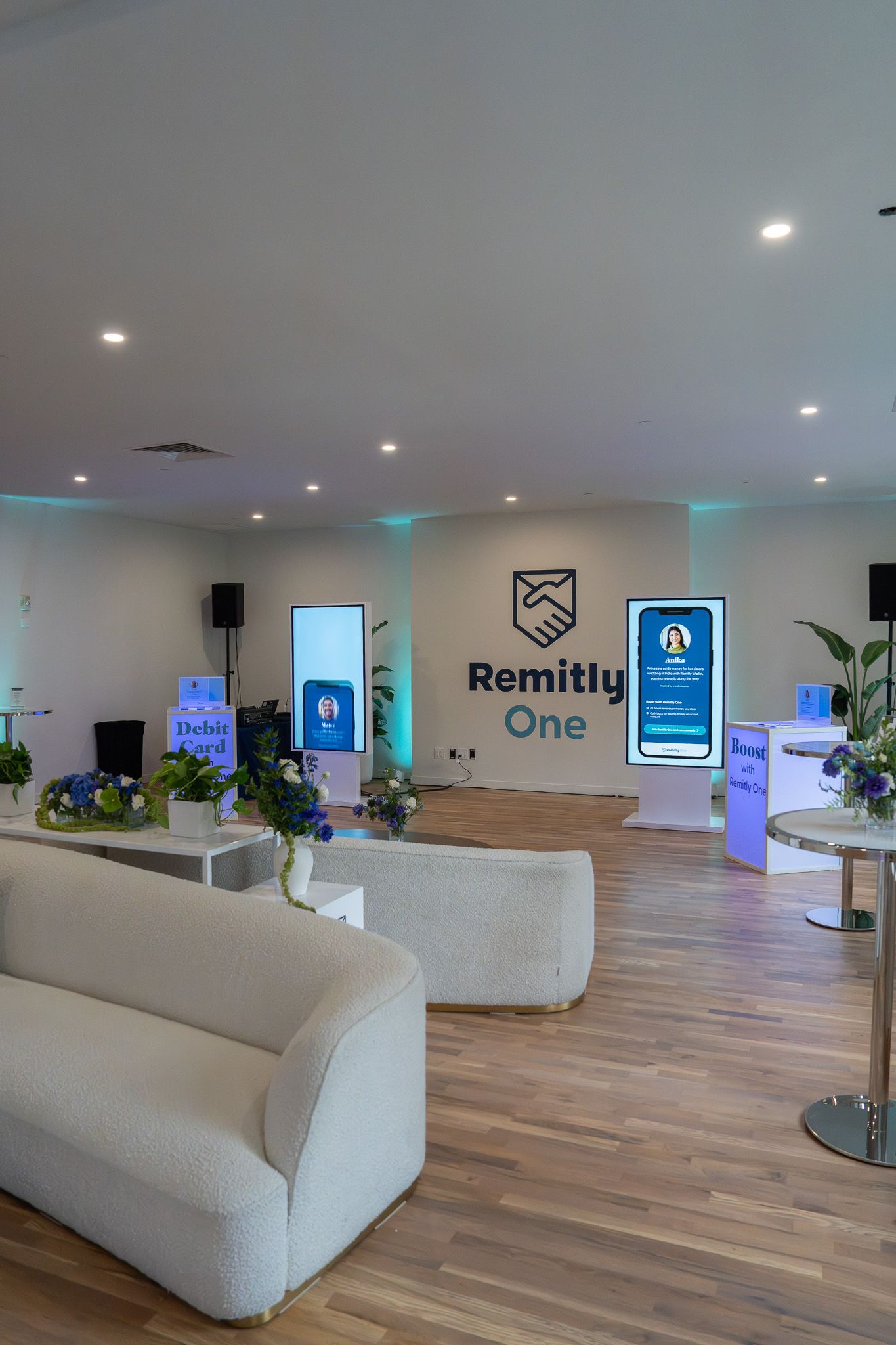 Modern office lobby with white sofas, plants, wood floor, and a “Ramley One” sign on the wall
