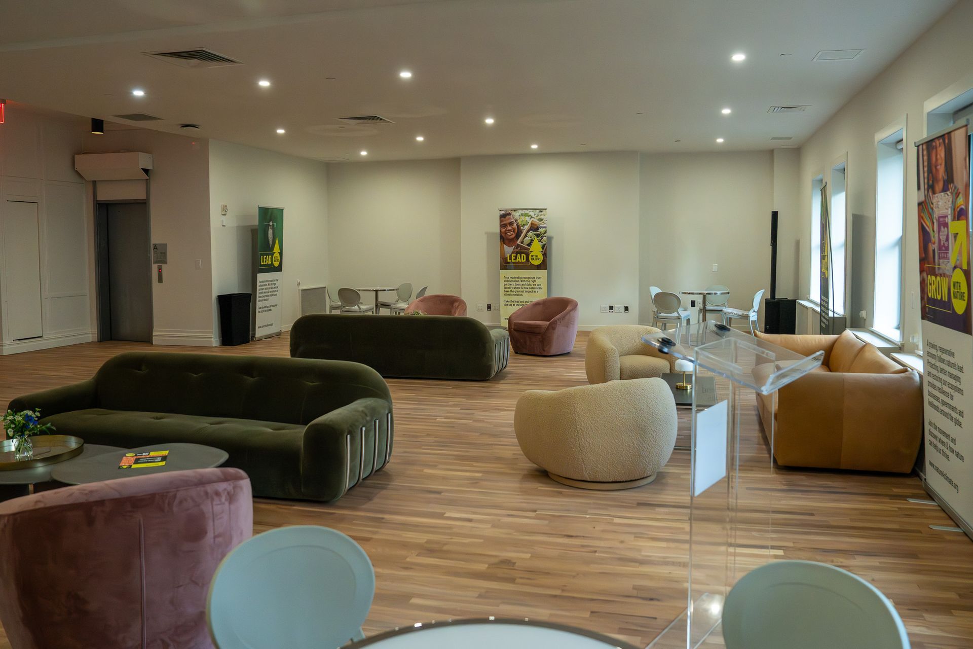 Modern lounge with colorful beanbag chairs and tables in a bright, wood-floored room