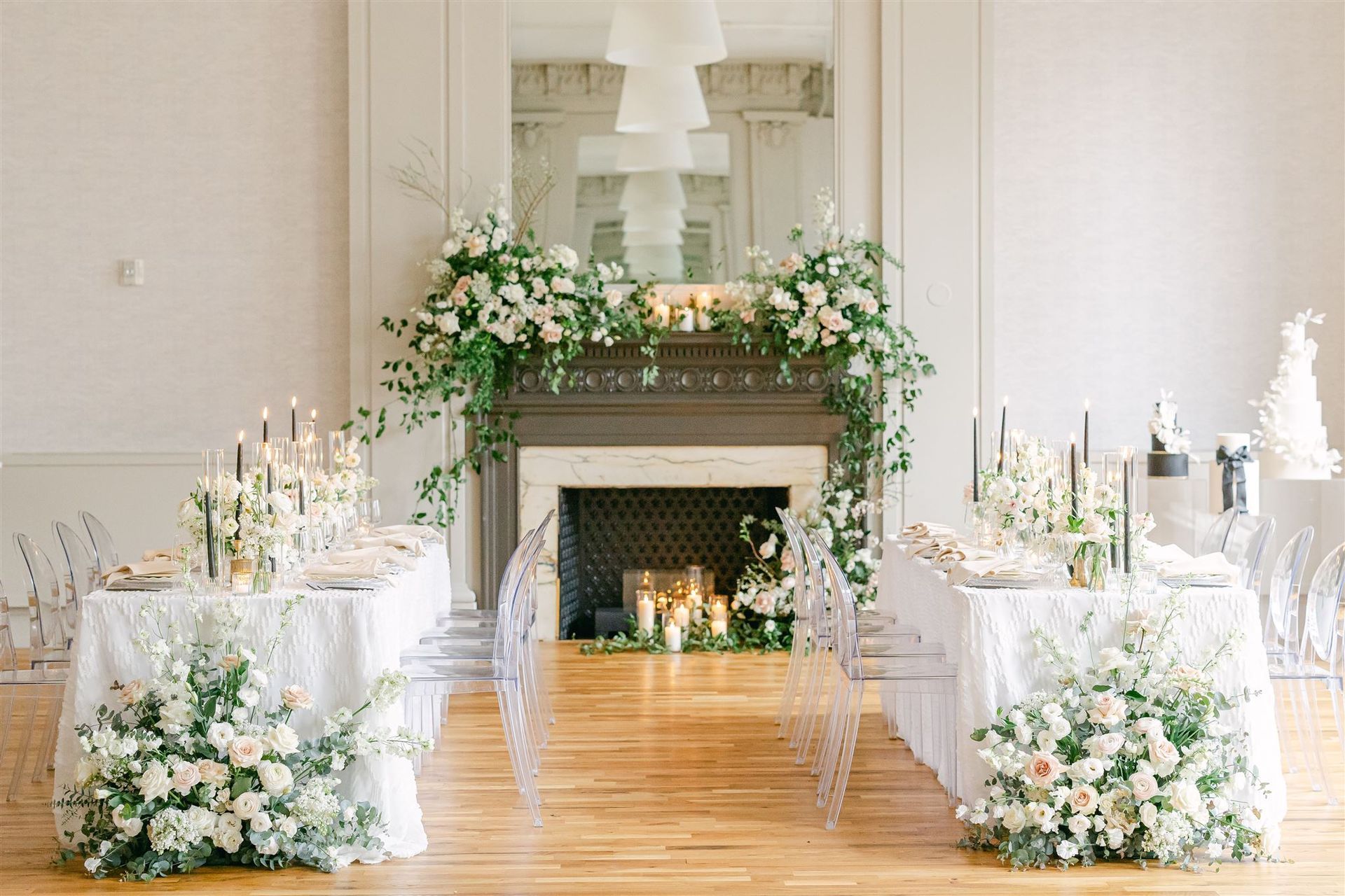 a room with tables and chairs and a fireplace decorated with flowers and candles .