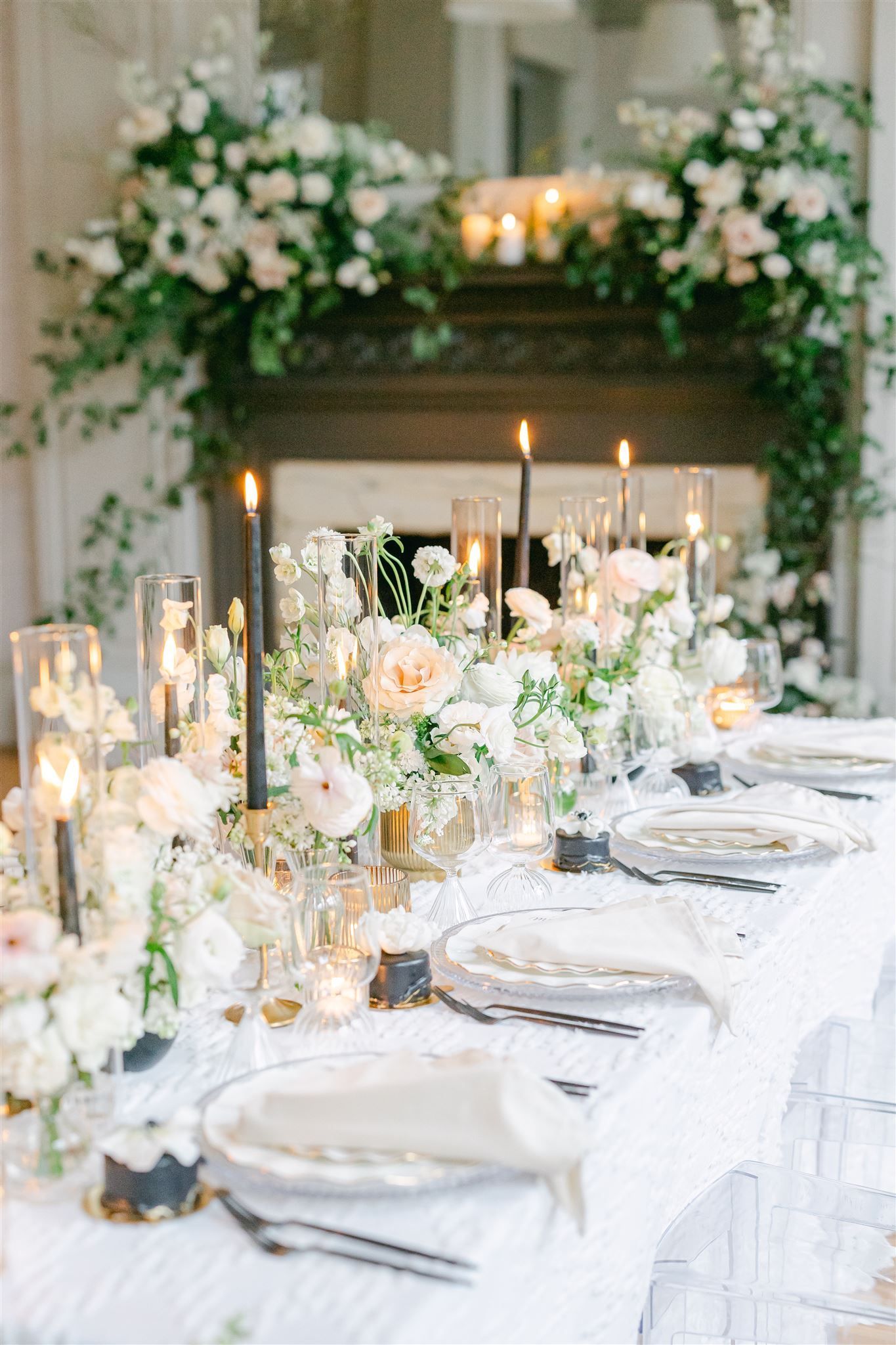 a long table with plates , candles , and flowers on it .