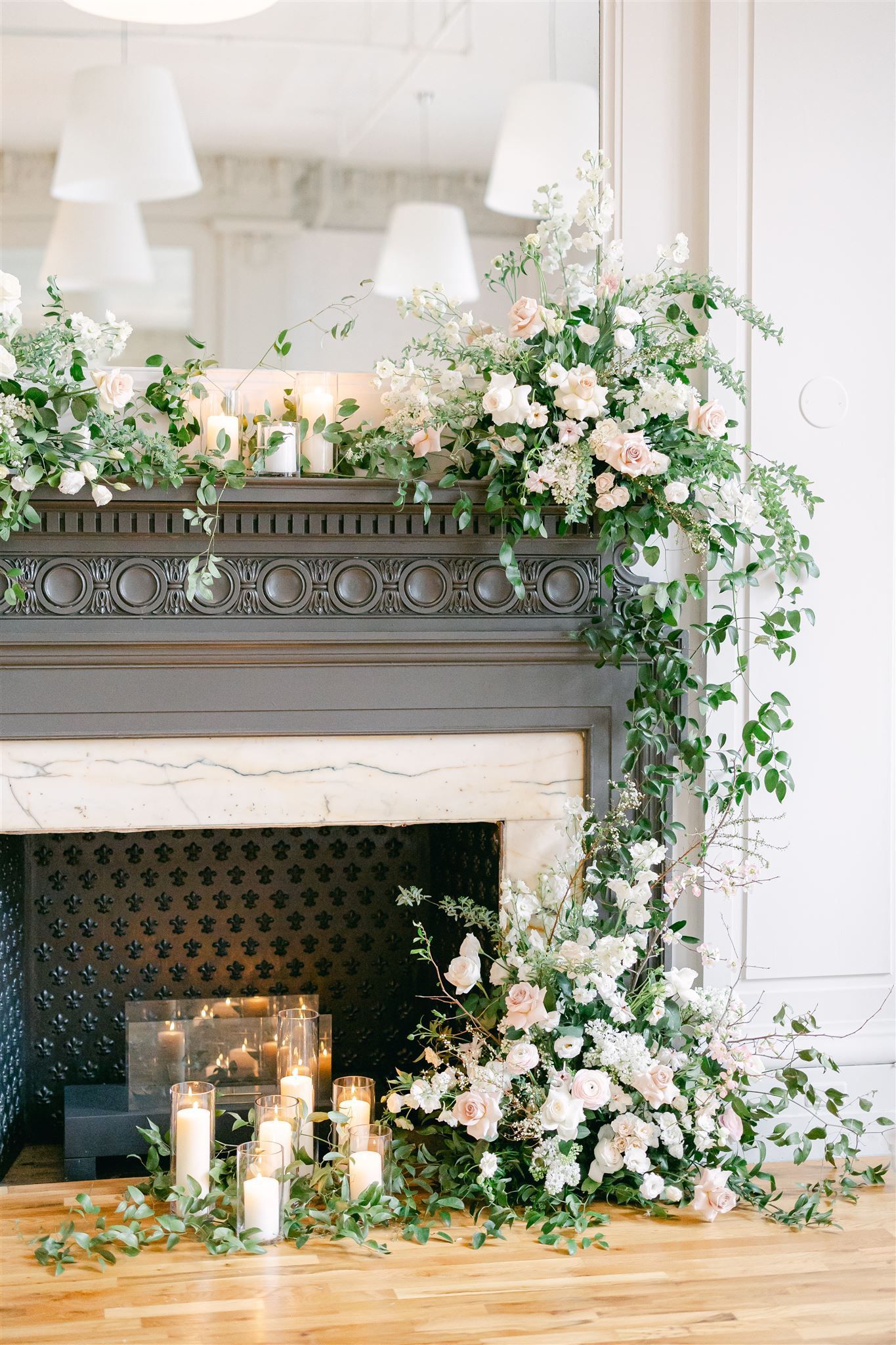 a fireplace decorated with flowers and candles for a wedding ceremony .