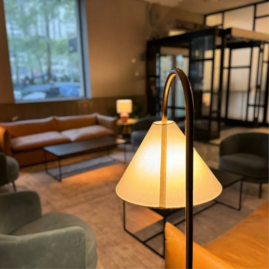 a lamp in a living room with a couch and chairs