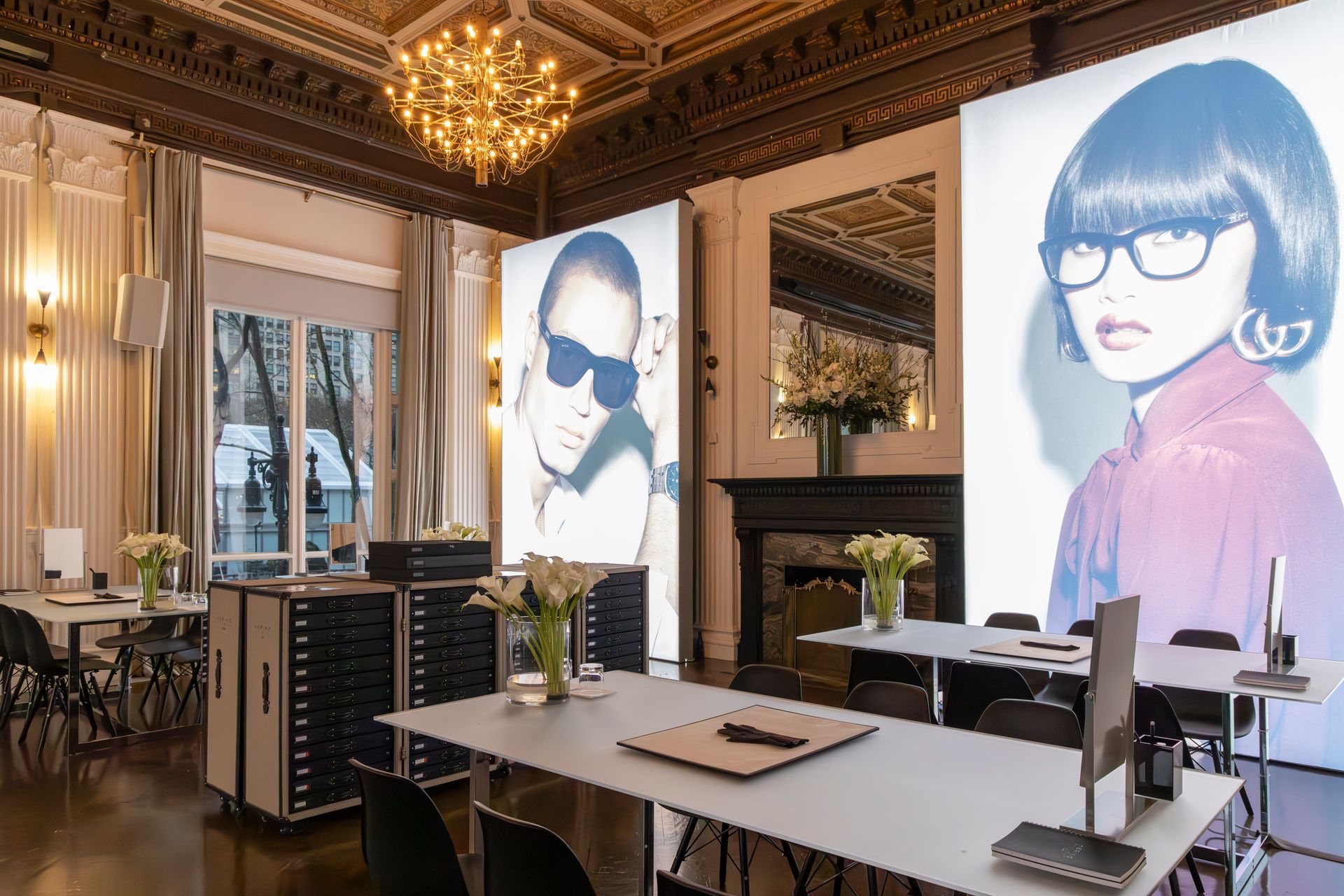 Elegant dining room with two large portrait posters, white table, and gold chandelier