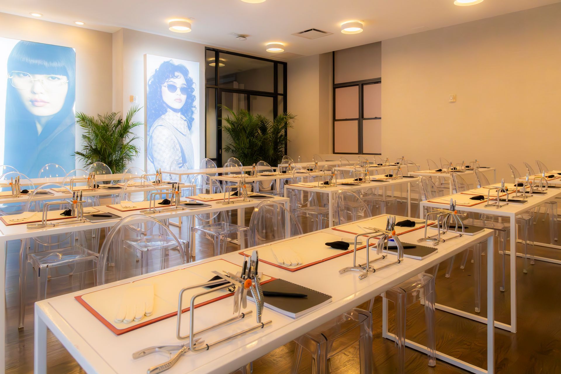 Modern classroom with transparent desks, notebooks, and wall portraits in a bright room