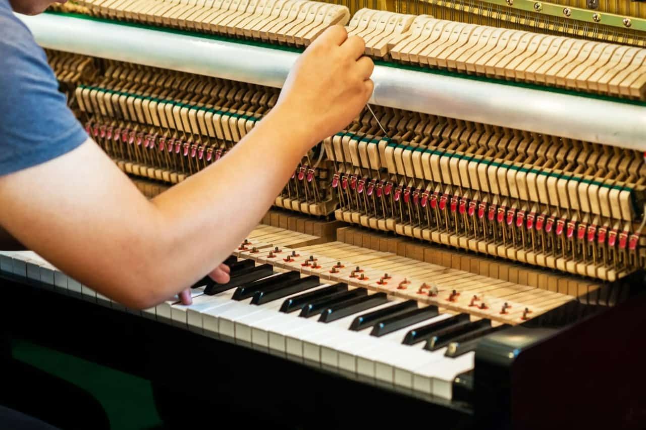A Man is Working on the Piano With a Tool  — Tony Prince Piano Tuning In Forster, NSW