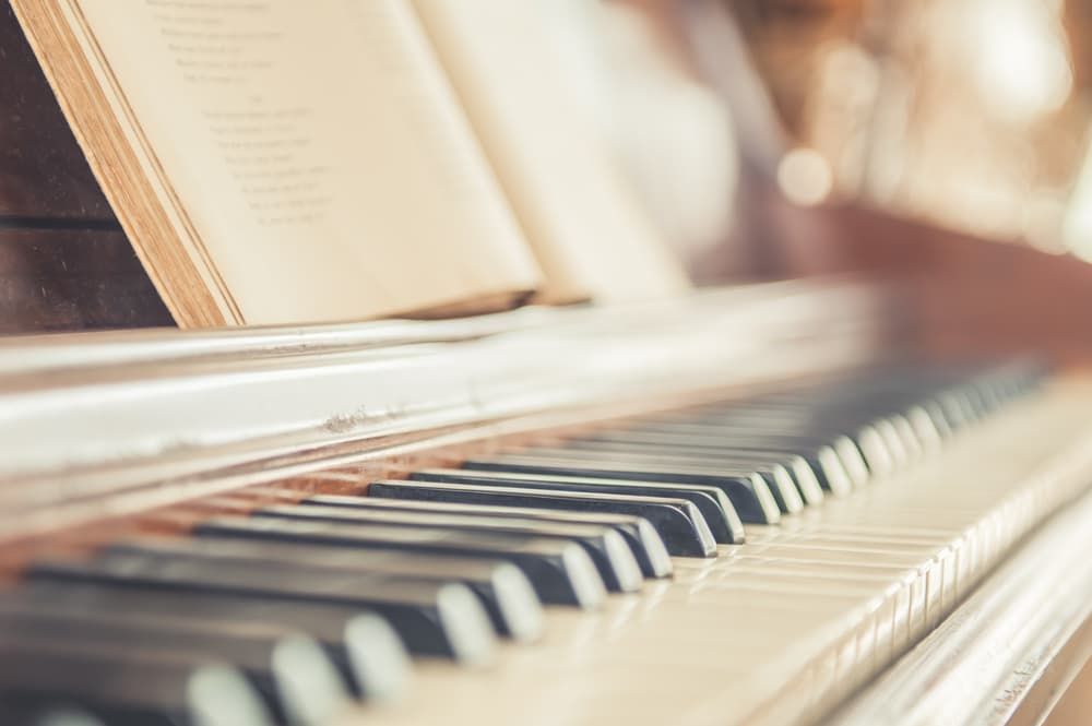A Close up Of a Piano Keyboard with A Book Sitting on Top of It — Tony Prince Piano Tuning In Taree, NSW