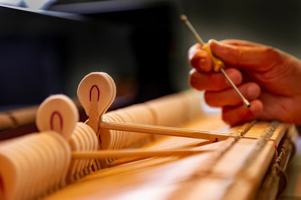 A Person Is Fixing a Piano with A Screwdriver — Tony Prince Piano Tuning In Port Macquarie, NSW
