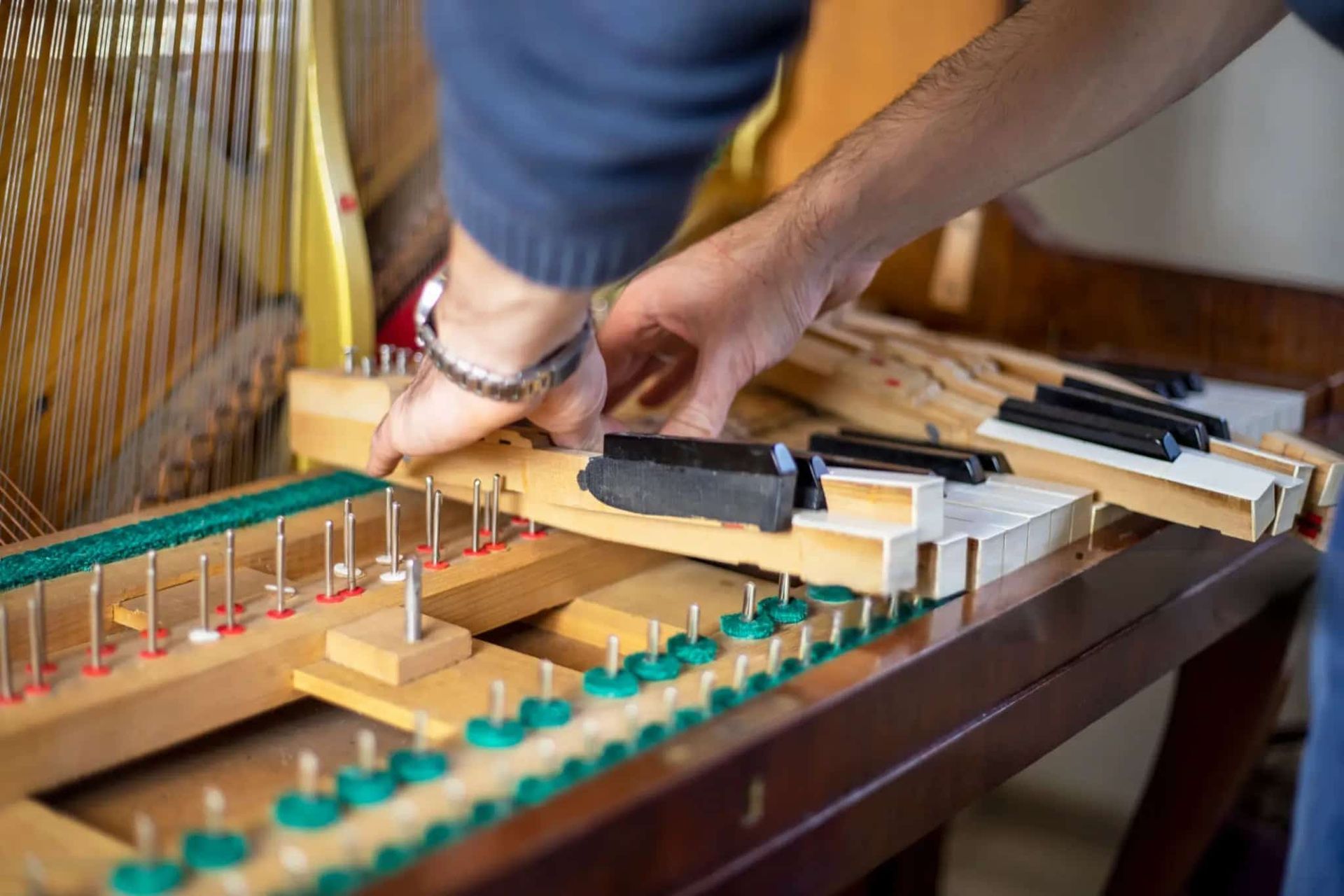A Man Is Working on The Inside of A Piano — Tony Prince Piano Tuning In Forster, NSW