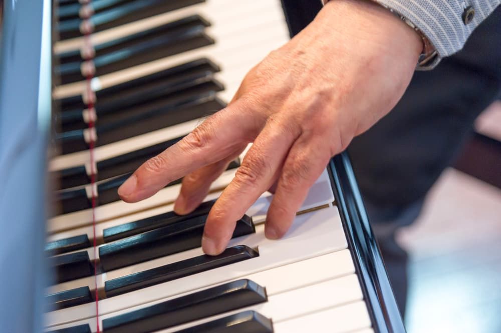A Close up Of a Person 's Hand Playing a Piano — Tony Prince Piano Tuning In Taree, NSW