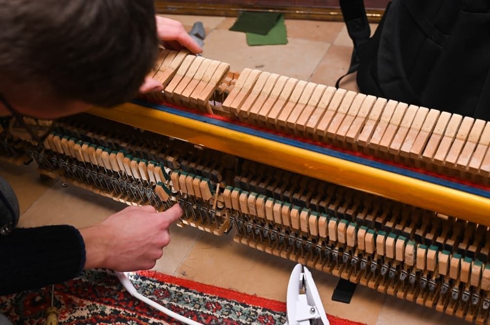 A Man Is Working on The Inside of A Piano — Tony Prince Piano Tuning In Taree, NSW
