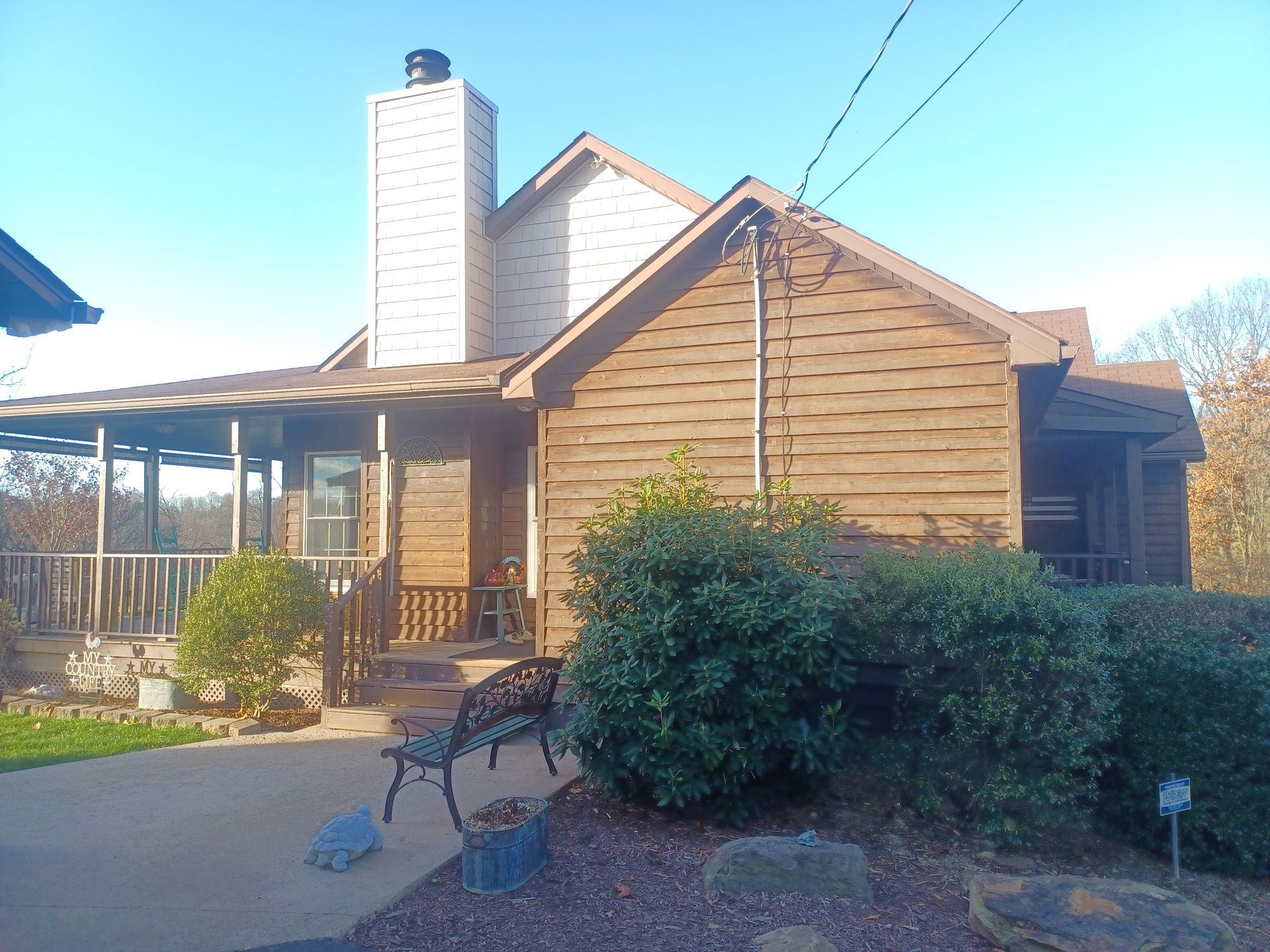The before of the house with a bench in front of it.