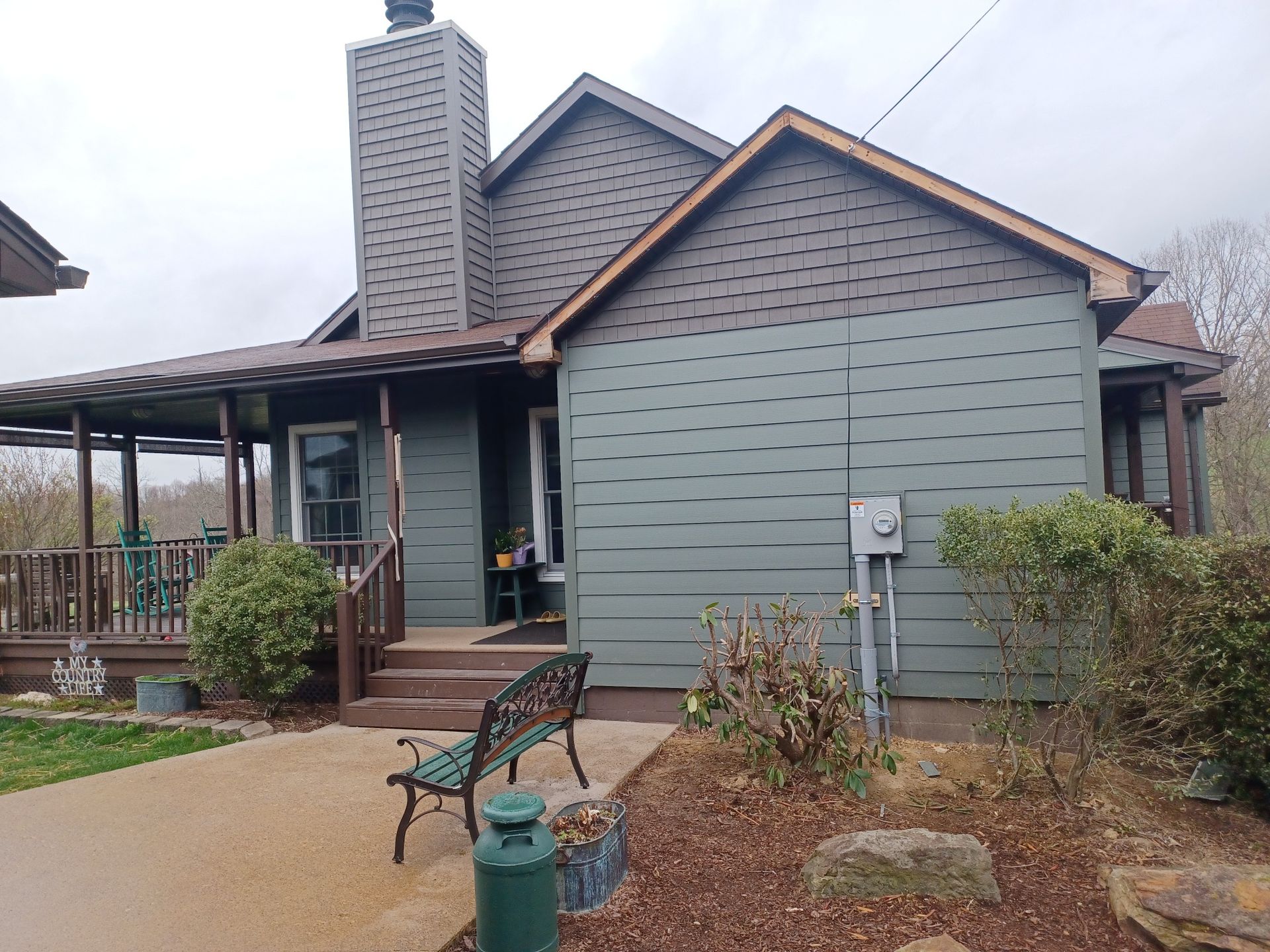 The after of the house with a bench in front of it.