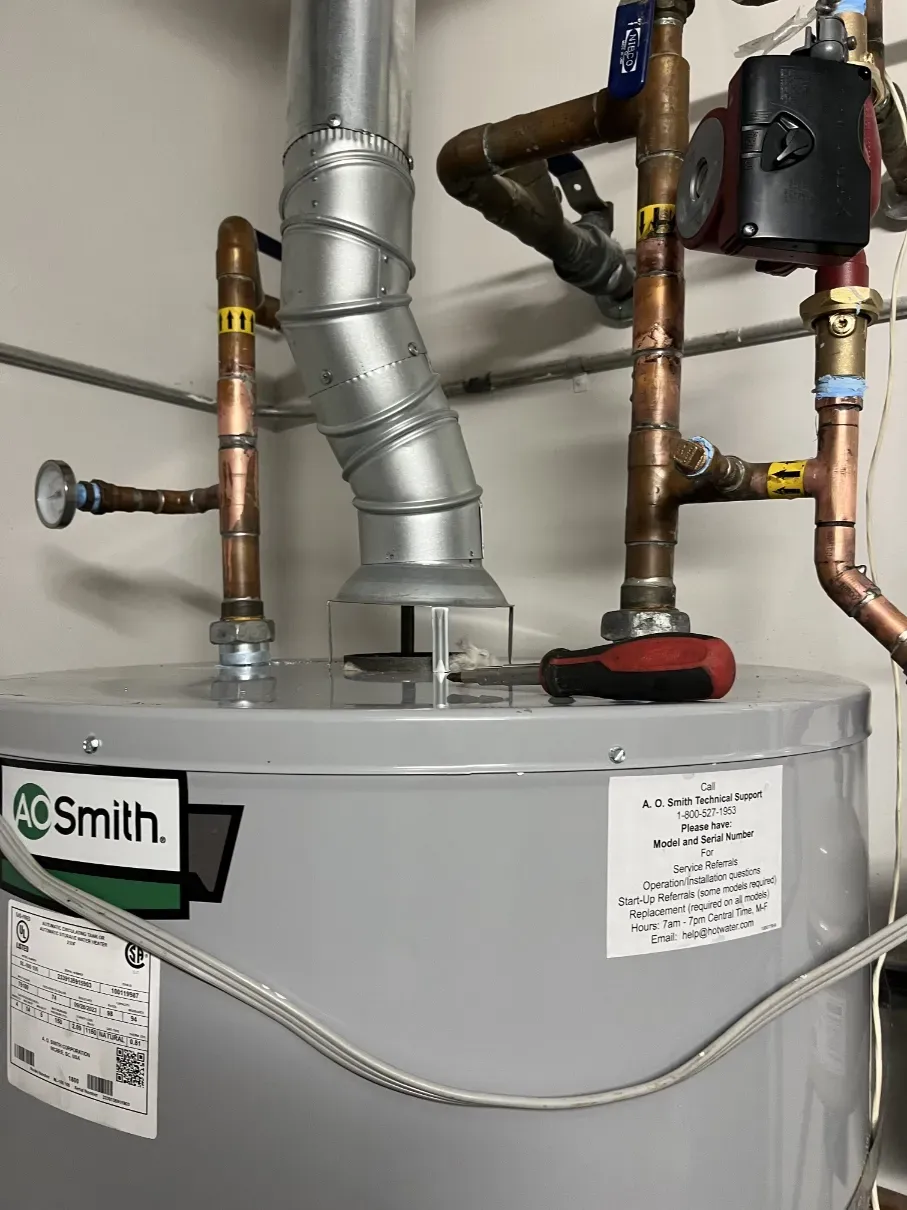 AO Smith water heater with copper plumbing and vent pipes in a utility room
