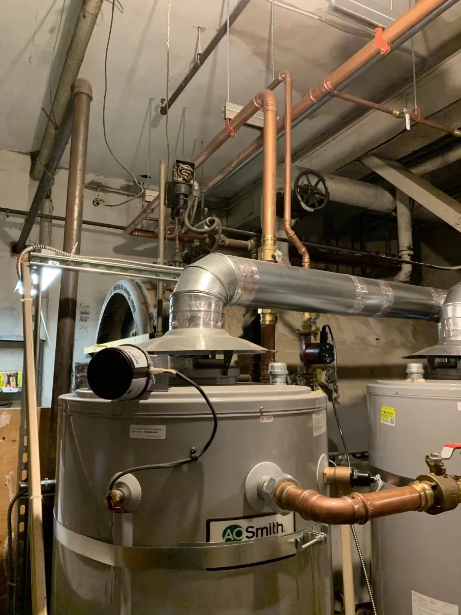 Large industrial boiler with metal ducting and pipes in a utility room