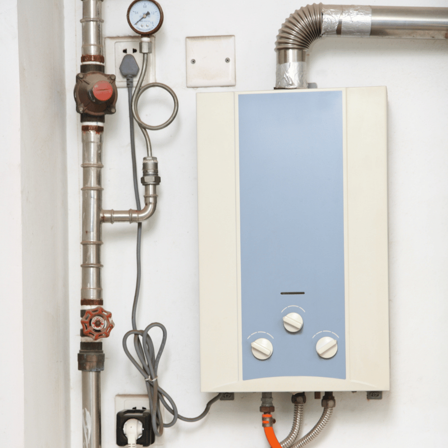 Wall-mounted water heater with dials, pipes, and pressure gauge, showcasing essential home heating equipment.