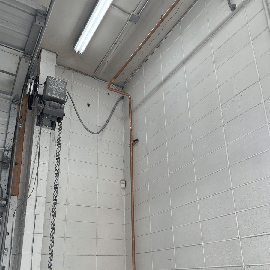 Copper pipe connected to a water heater in a utility room, showcasing plumbing installation and equipment.