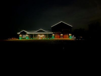 A house is lit up with christmas lights at night.