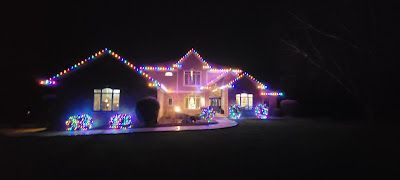 A house is decorated with christmas lights at night.
