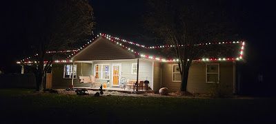 A house is decorated with christmas lights at night.