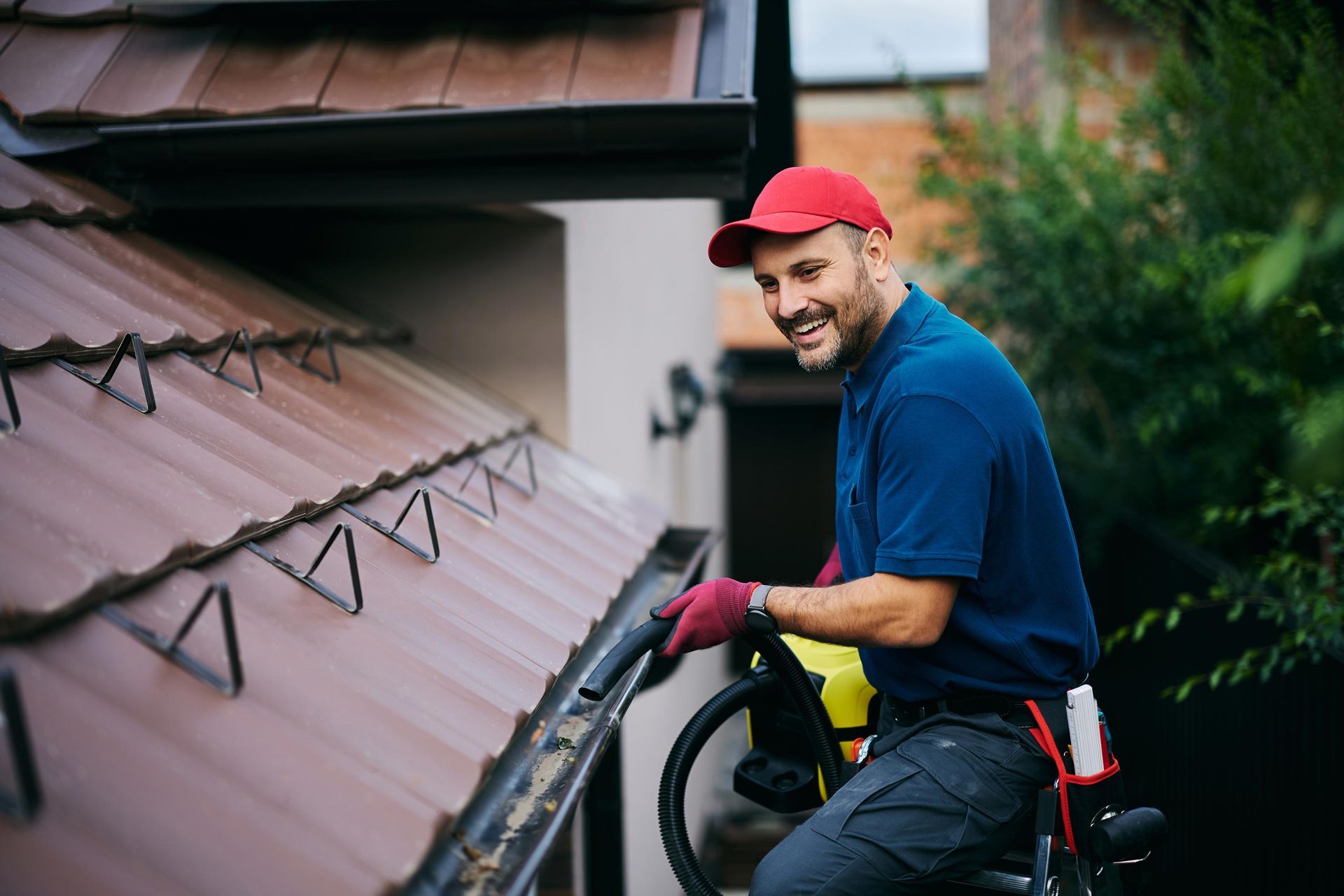 Professional performing gutter cleaning and maintenance on a residential roof.