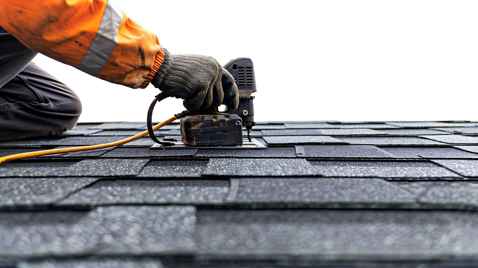 Roofing contractors installing asphalt shingles using nail gun on residential roof close-up. Roofing contractors installing asphalt shingles using nail gun on residential roof close-up.