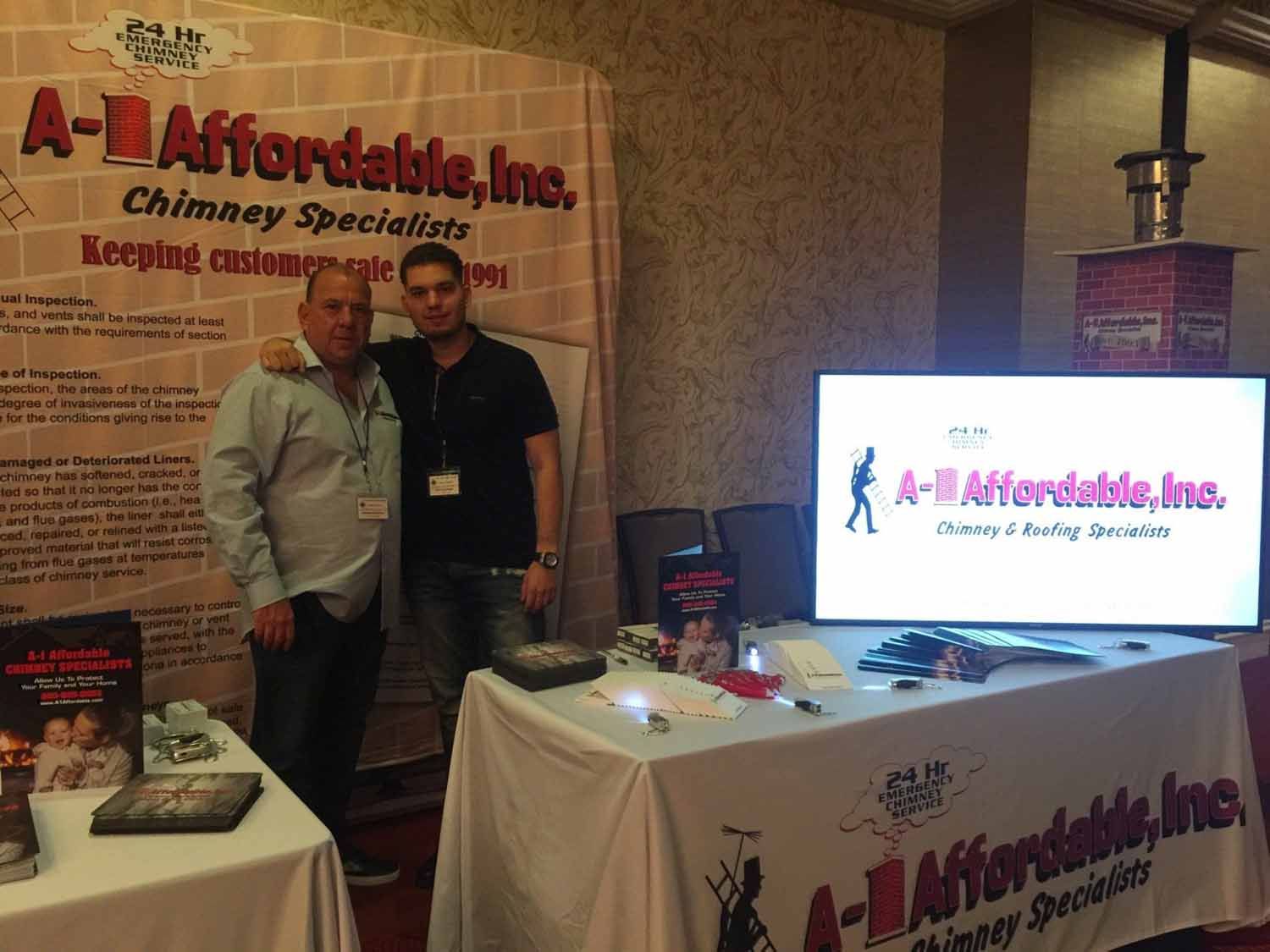 Two men stand at a booth for 