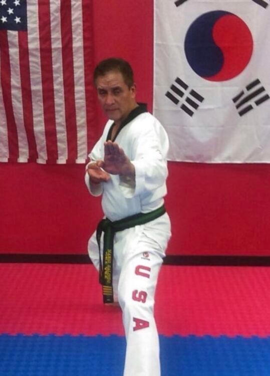 Man in martial arts uniform in a fighting stance.