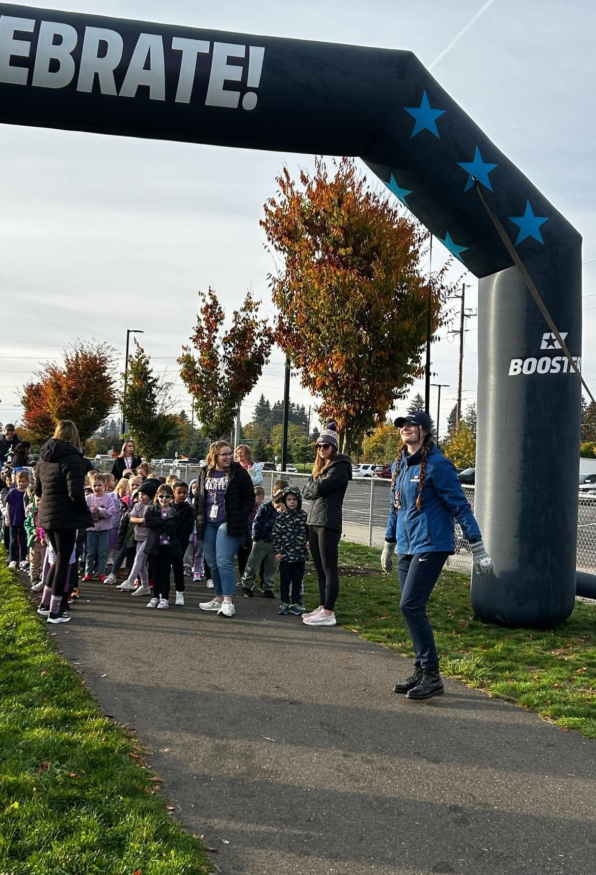 People at a race starting line under an archway that reads