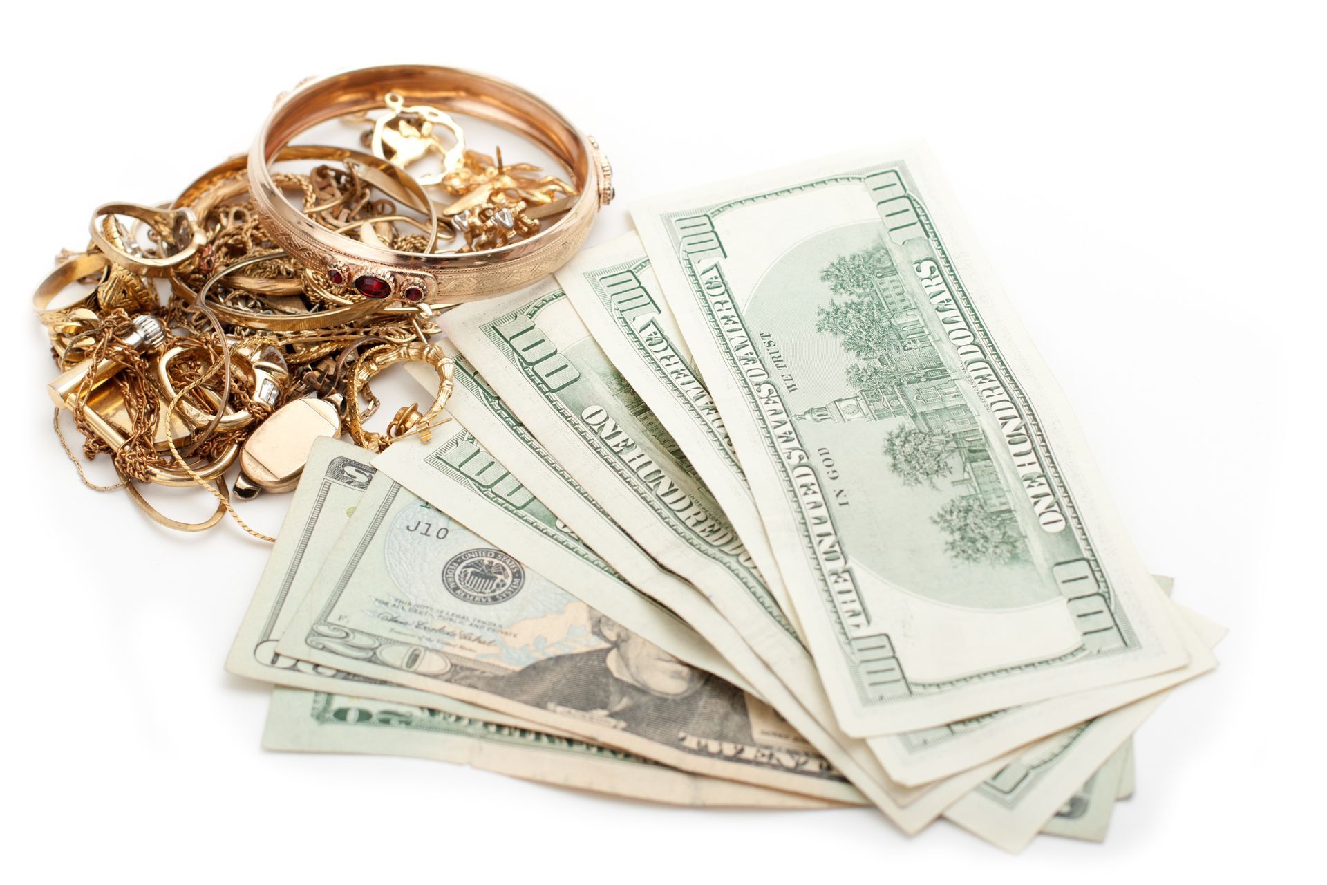 Gold jewelry and US dollar bills on a white background