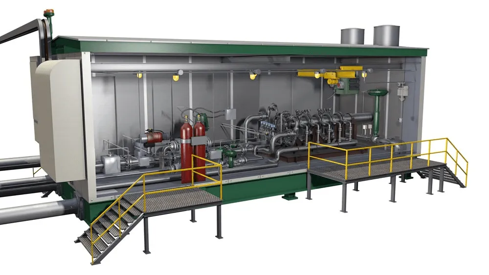 Industrial machinery inside a large gray facility with yellow railings and a front staircase