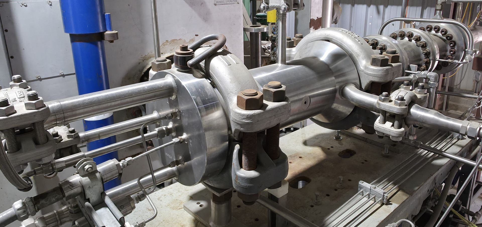 Industrial piping and valves in a plant, with stainless steel equipment and connected pipes on a metal platform
