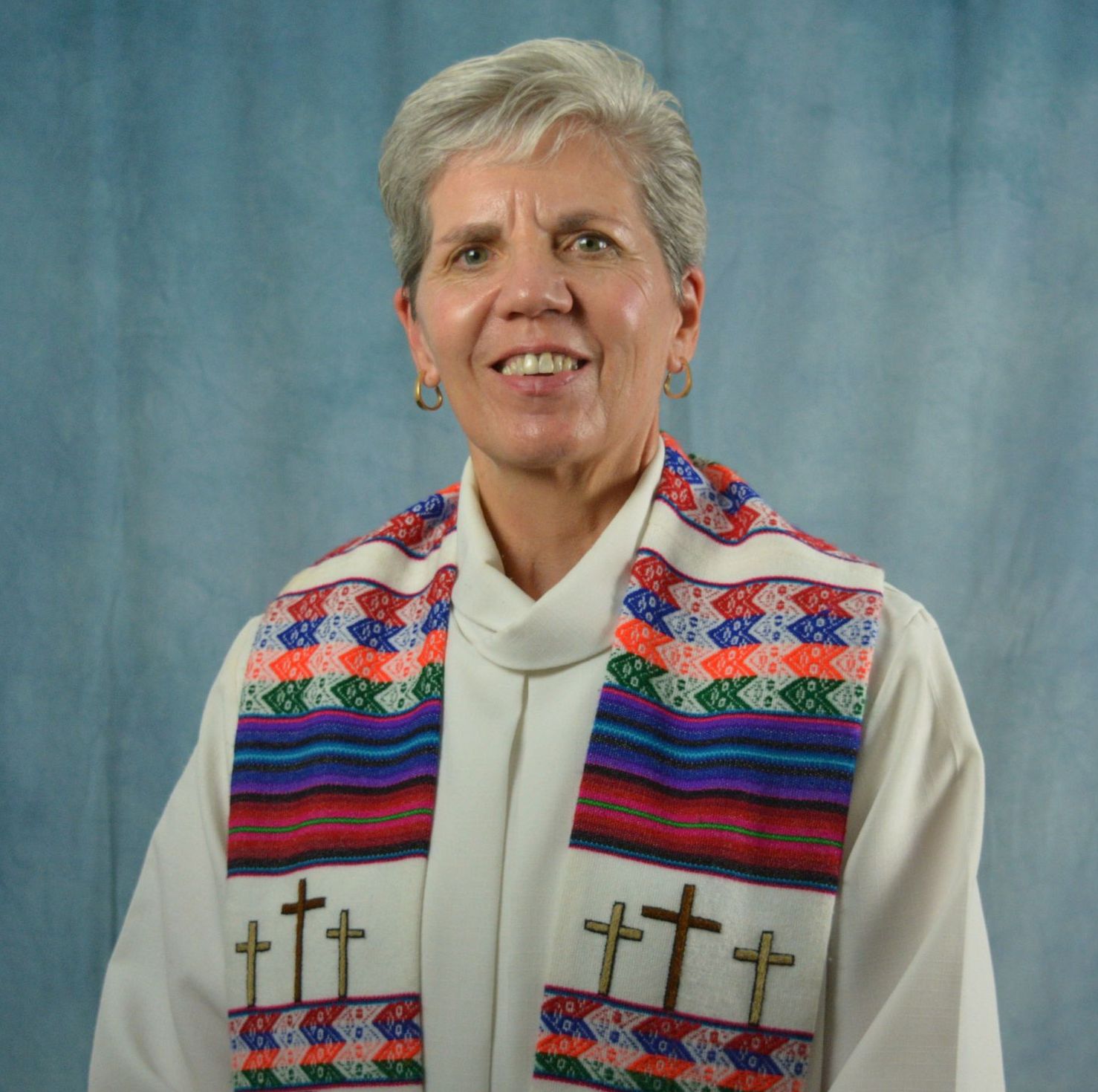 A woman wearing a colorful scarf with crosses on it