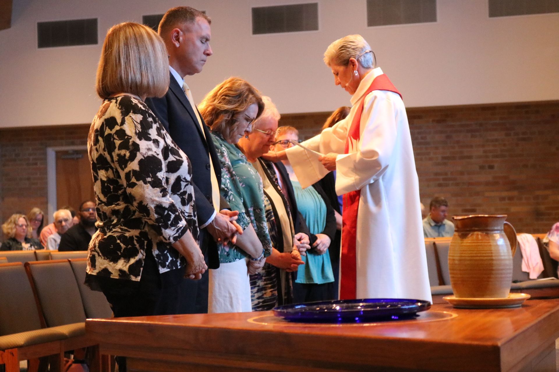 Pastor giving communion to a line of congregants in a church sanctuary