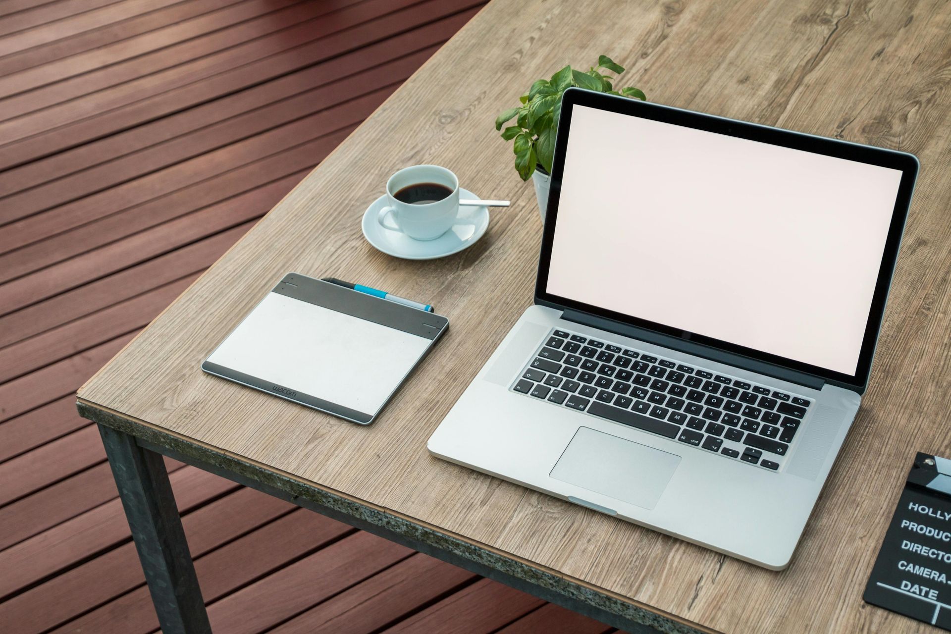 A laptop computer is sitting on a wooden desk next to a cup of coffee.