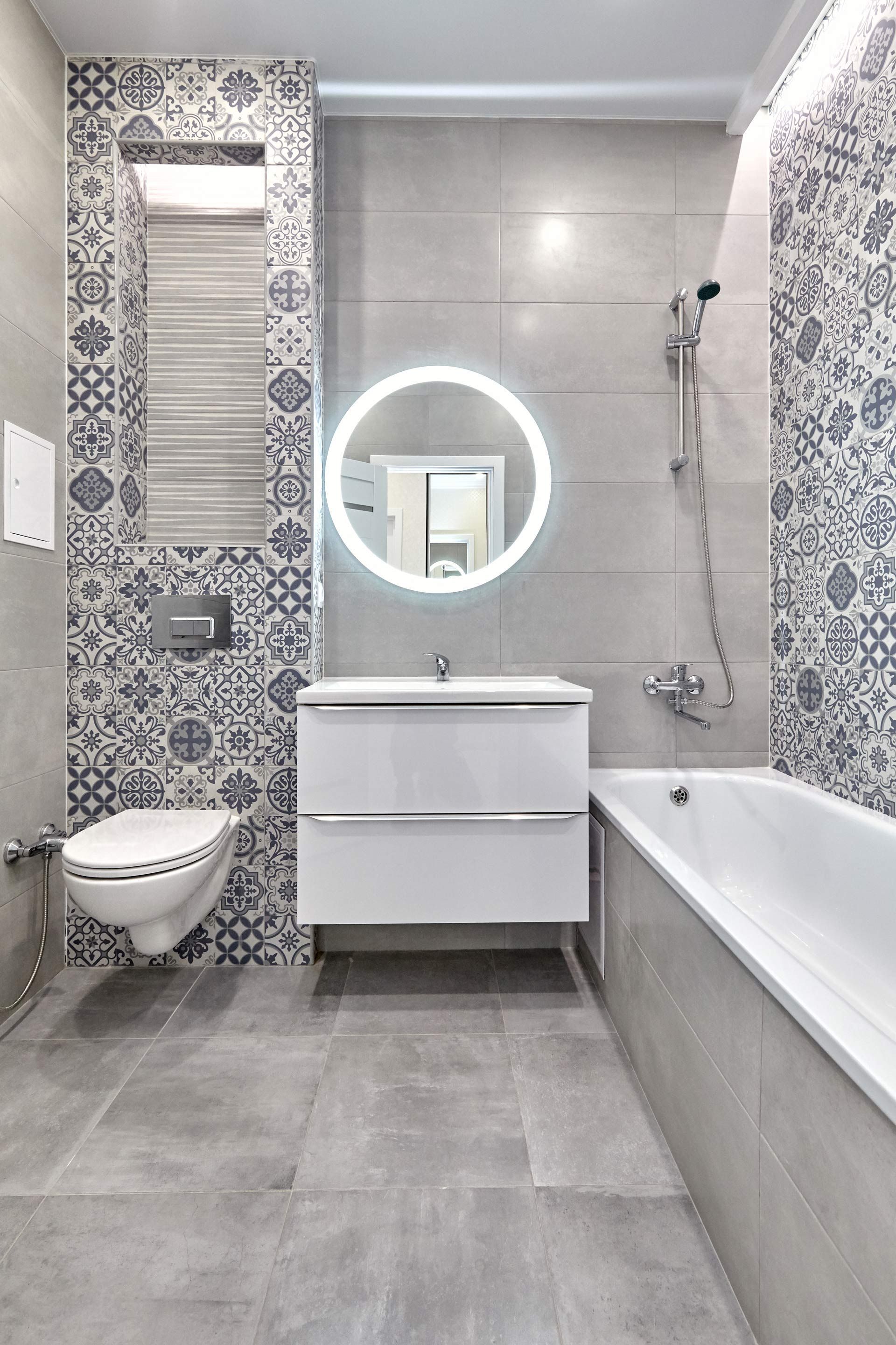 A bathroom with a toilet , sink , bathtub and mirror.