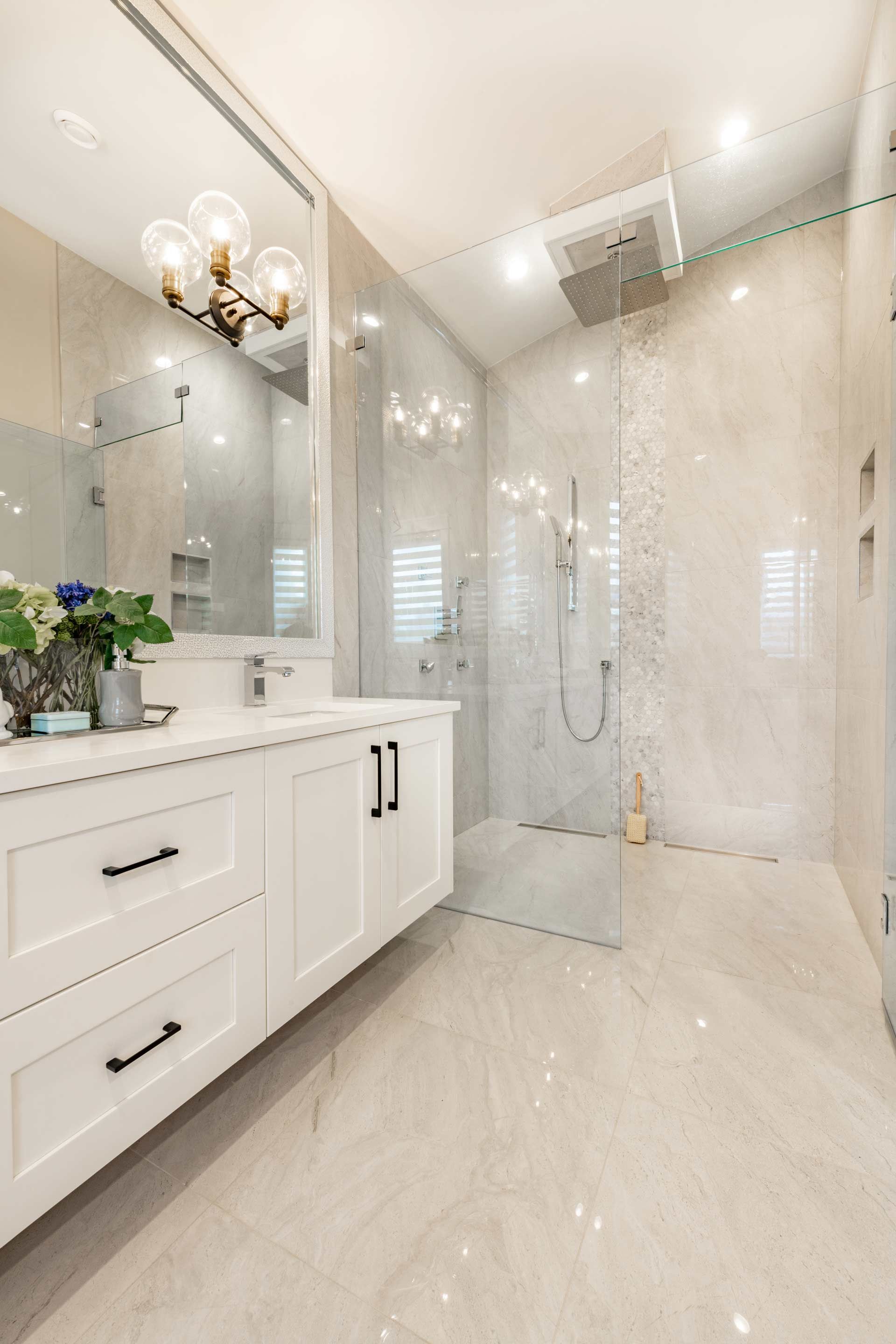 A bathroom with a walk in shower , sink and mirror.