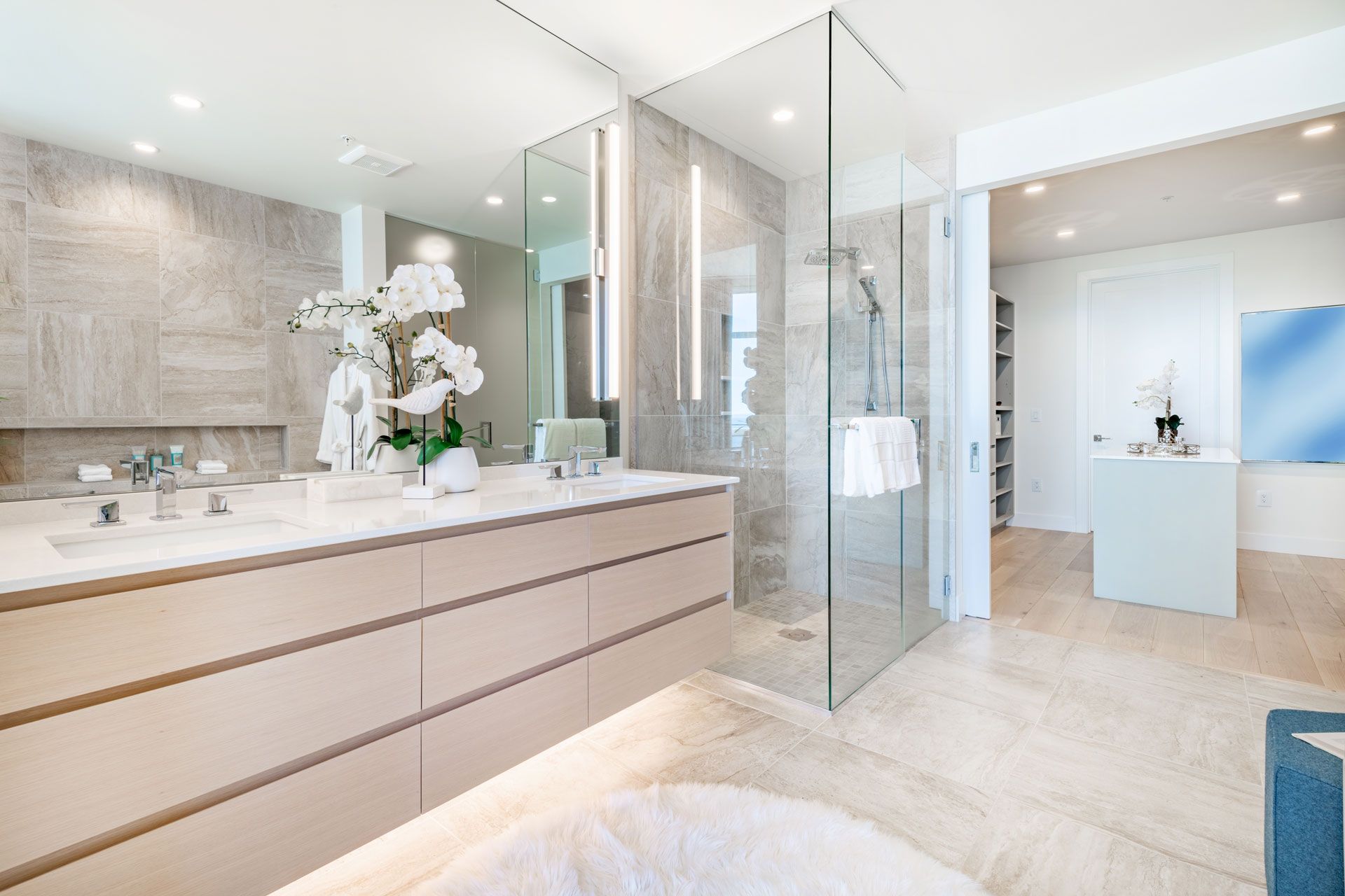 A bathroom with two sinks , a walk in shower and a large mirror.