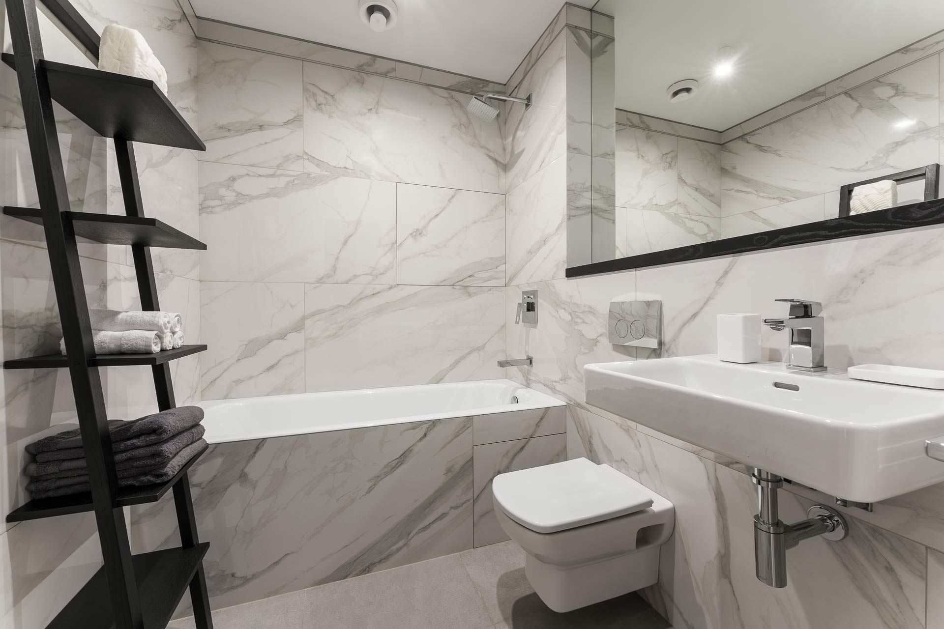 A bathroom with a sink , toilet , bathtub and mirror.