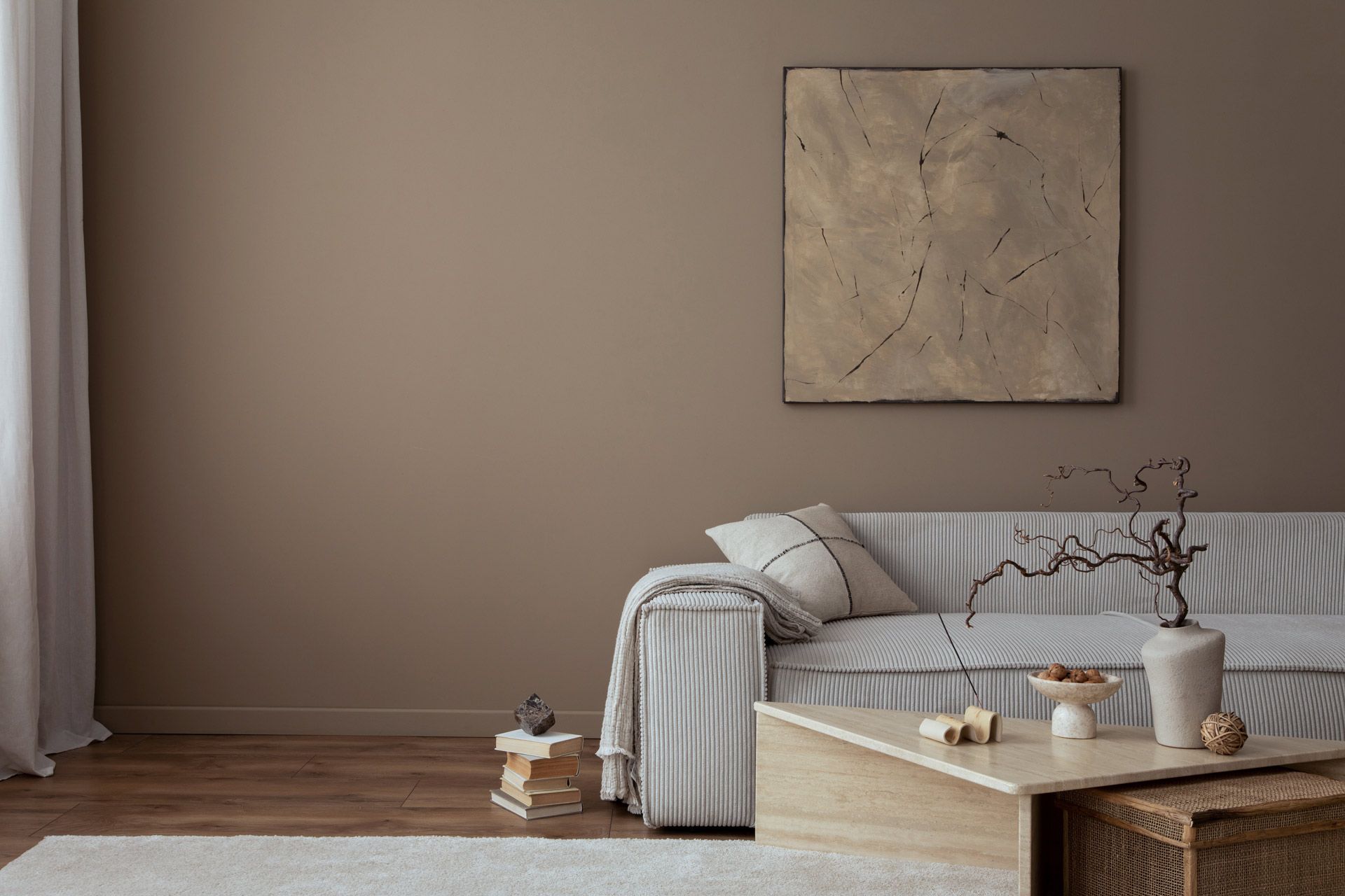 A living room with a couch , coffee table , and painting on the wall.